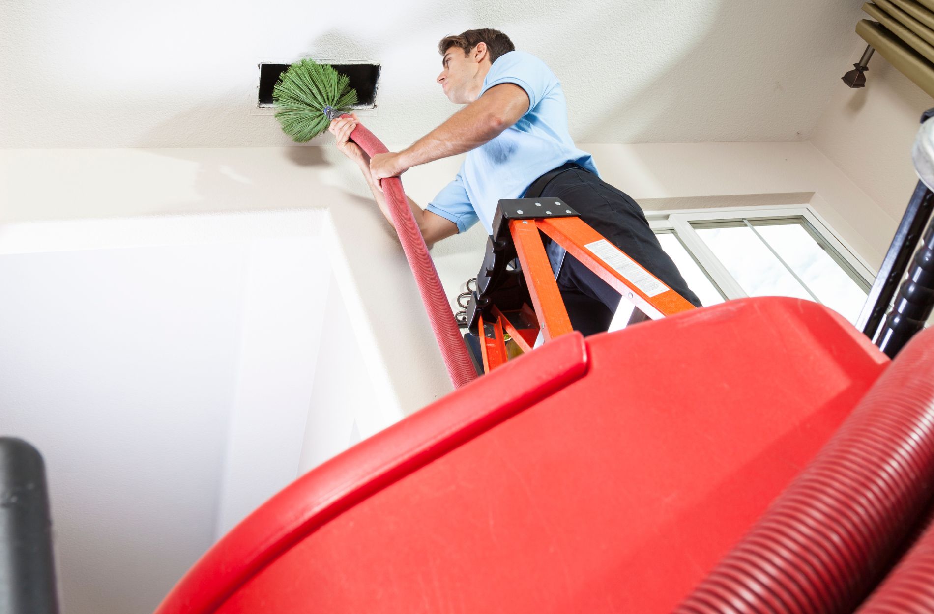 Man cleaning air ducts in home