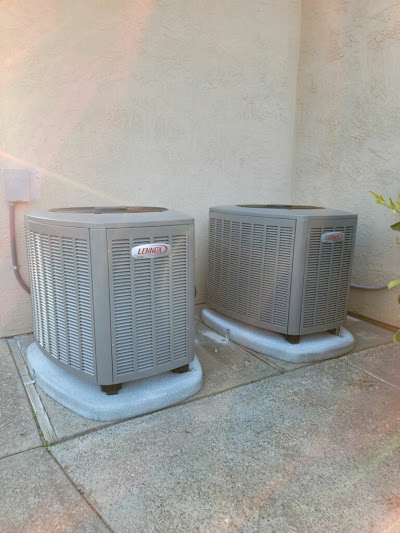 Two air conditioning units placed on a patio