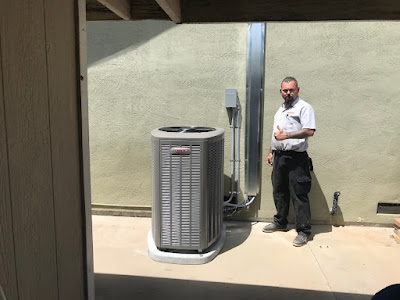 A man stands beside a large air conditioner