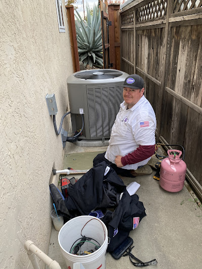 HVAC Technician working on the AC unit